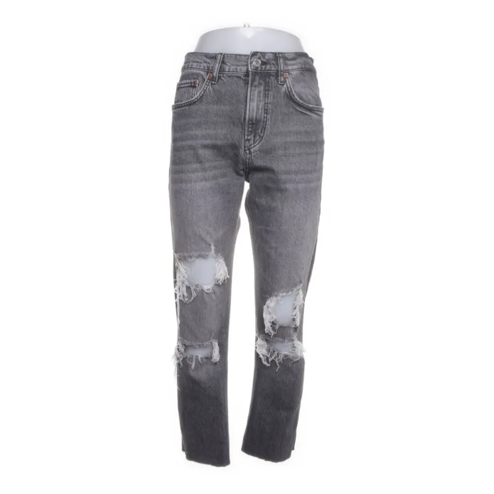 Säljer ett par grå jeans med slitningar på knäna. De är högmidjade och har en straight passform. Köpta på Sellpy med prislapp kvar!. Jeans & Byxor.