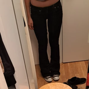 Lågmidjade utsvängda jeans - De har blivit insydda vid skrevet då de brukade vara högmidjade, se bilder för hur det ser ut på närbild. Storleken var M men efter de har blivit omsydda skulle jag säga ca S. 110cm långa, midjemåttet är 35cm och längst ned 26cm breda💕