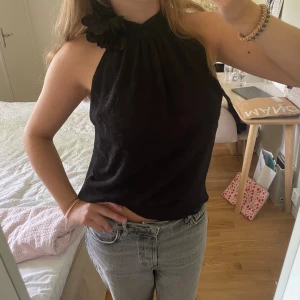 Halterneck topp - Intressekoll!! Cool halterneck topp med en blomm-detalj vid halsen och glittrigt mönster!