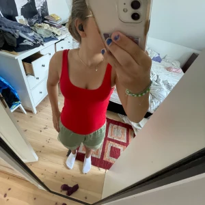 Röd ribbad linnetopp från Holly & White - Säljer en snygg röd ribbad linnetopp från Holly & White. Den är ärmlös och perfekt för sommaren. Toppen har en tight passform och är gjord i ett mjukt material som känns skönt mot huden. Perfekt för både vardag och fest!