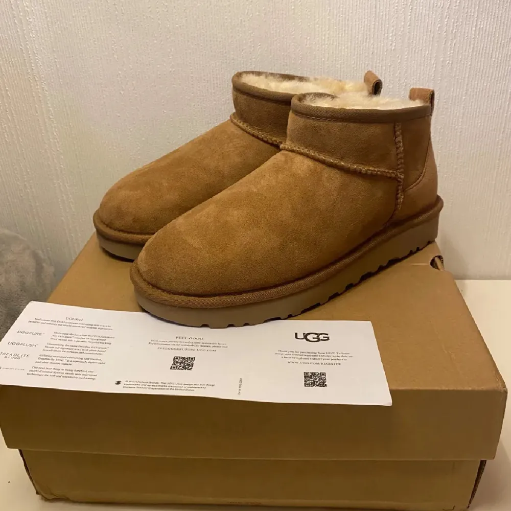 Säljer ett par supermysiga bruna UGG boots i mocka. De har en fluffig insida som håller fötterna varma under kalla dagar. Perfekta för höst och vinter! De är i nytt skick och kommer i originalkartong. Skickar gärna fler bilder om de önskas 💞. Skor.