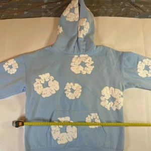 Ljusblå hoodie med vita molnmönster - Säljer en supermysig ljusblå hoodie med coola vita molnmönster. Perfekt för chill dagar eller när du vill ha något bekvämt och stiligt. Den har en klassisk känguruficka och en skön huva. Passar perfekt till jeans eller mjukisbyxor. 🌀