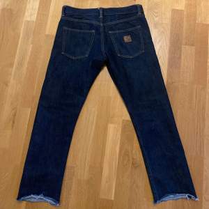 Knappt ingångna Carhart jeans i raw selvedged denim. 