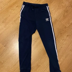 Blå mjukisbyxor från Adidas - Säljer ett par snygga blå mjukisbyxor från Adidas. Byxorna har en bekväm passform och är perfekta för både träning och chill. Pris kan diskuteras.
