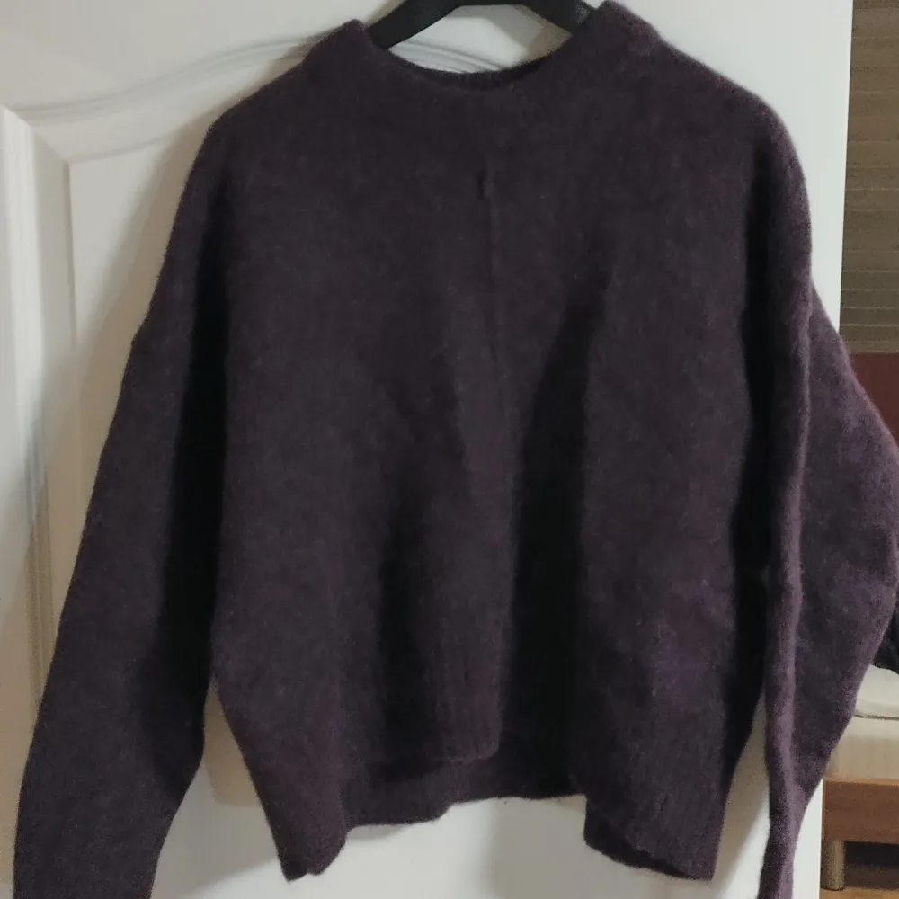 Säljer en supermysig mörklila stickad tröja från Lindex. Perfekt för kyliga höst- och vinterdagar. Tröjan har långa ärmar och en enkel design som gör den lätt att matcha med olika outfits. Den är i bra skick och redo för en ny ägare!. Neuletakit & Villapaidat.
