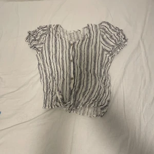 Vit sommar bluse med blåa streck  - Hej! Jag säljer en vit sommar bluse med mörkblåa streck. Den är till för barn mellan 7-10. Jag kan skicka fler bilder om det behövs. 💕