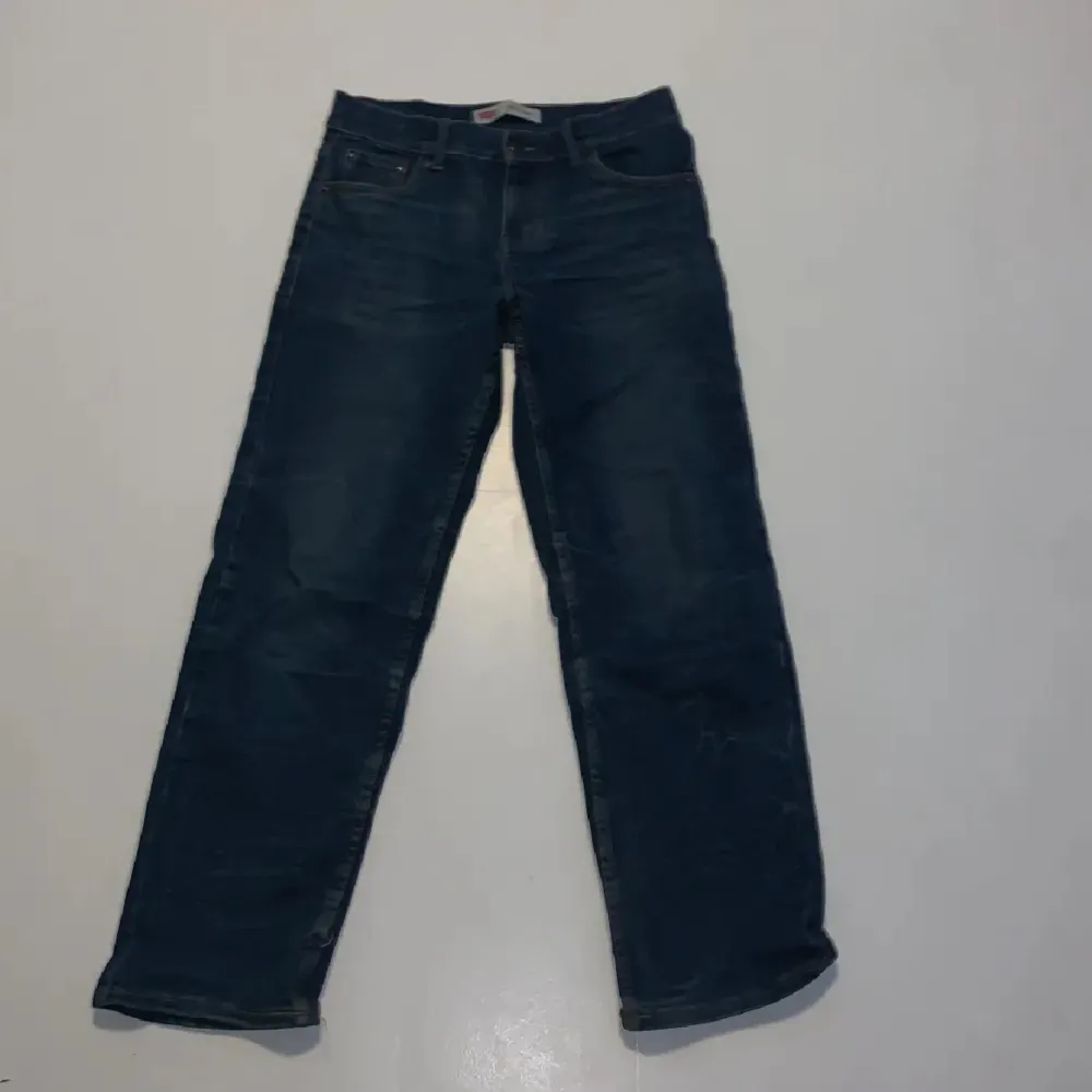 Säljer ett par Levi's jeans i blå färg. De är i modellen Loose Taper och har en klassisk femficksdesign med knapp och dragkedja i gylfen. Jeansen är i bra skick och passar perfekt för en avslappnad stil.. Jeans & Byxor.