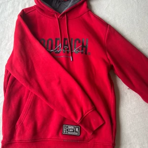 Röd hoodie från Hoodrich - Säljer en röd hoodie från Hoodrich. Hoodien är i storlek M och har en ficka fram samt en gömd ficka på armen. Hoodien är i jättebra skick och inte använd många gånger alls. 