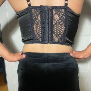 Urban outfitters corset - Säljer en snygg svart korsett i storlek S och XS Den har fina spetsdetaljer både fram och bak, och en dragkedja på baksidan. Perfekt för fest eller en utekväll! 🖤