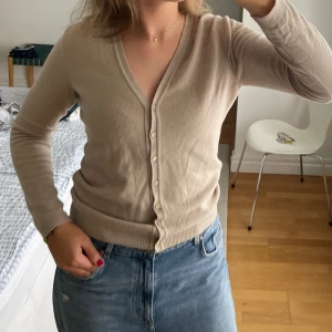 Beige kofta med knappar - Fin beige stickad kofta i bomull från United Colours of Benetton. Storlek M!