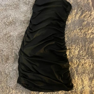 Svart klänning - Endast testad svart klänning med snygga detaljer längs sidorna