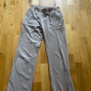 Beige mjukisbyxor från Juicy Couture - Säljer ett par supermysiga beige mjukisbyxor från Juicy Couture i storlek XS. Byxorna har en medel hög midja men går självklart att sy eller vika ner vid preferenser,  och är tillverkade i ett mjukt och bekvämt material.