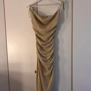 Klänning Nakd  - Snygg guld glittrig klänning från Nakd. Köpt från second hand. Säljes då den inte passar min byst storlek, men sitter annars jätte fint och skönt på kroppen☀️