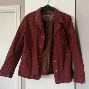 Röd jacka från Murphy & Nye - Säljer en snygg röd jacka från Murphy & Nye. Jackan har långa ärmar och knappar framtill. Den är tillverkad i ett slitstarkt material och har en klassisk krage. Vintage . Står ingen strl men uppskattar till s-m. 