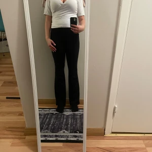 Vit omlottopp - Säljer en stilren vit omlottopp med korta ärmar. Toppen har en v-ringad design som ger en elegant look. Perfekt för att matcha med både jeans och kjol.