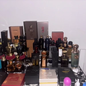 Olika sorters parfymer för salu eller bytes - En imponerande samling av exklusiva parfymer med olika märken och design. Flaskorna varierar i färg och form, inklusive guld, svart och rött. Märken som YSL och Dior syns tydligt. Perfekt för den som älskar lyxiga dofter