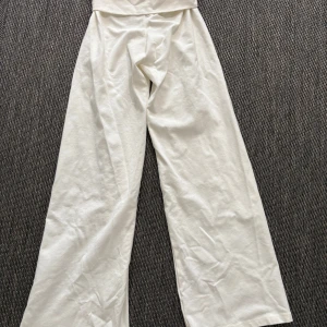 Fold byxor Brandy Melville - Snygga vita byxor från Brandy Melville med en folded design och vida ben. Perfekta för en stilren look. Tillverkade i ett mjukt och bekvämt material som ger en skön passform. • Aldrig använd, prislapp kvar •