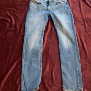 Blå jeans från Dressmann - Snygga blå jeans från Dressmann i en klassisk straight fit. De har en midwaist design och är tillverkade i jeansmaterial. Perfekta för en avslappnad stil. Jeansen är i Storlek 31-32. Använda fåtal gånger så utmärkt skick! 