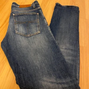 Tiger of Sweden jeans - Snygga blå jeans med en klassisk femficksdesign och coola slitningar. De har en rak passform och är perfekta för en avslappnad stil. Jeansen har en knappgylf och är tillverkade i ett robust denimtyg. Priset kan diskuteras vid snabb affär 😃😃