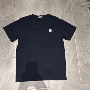 Mörk blå T-shirt från Moncler - Säljer nu min väldigt fina moncler T-shirt. Den är i väldigt bra skick, har aldrig andvänt den. Storlek L, men passar även M. Den ❗är❗dock❗en❗rep❗. Skriv om ni har flera frågor!