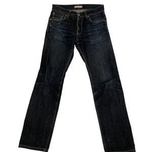 Svarta Uniqlo jeans  - Snygga svarta jeans från Uniqlo i en straight passform. Tillverkade av japanskt tyg från Kaihara. Perfekta för en stilren look med klassisk design och medelhög midja. Storlek W29 L32 perfekt för dig som är runt 180cm lång.