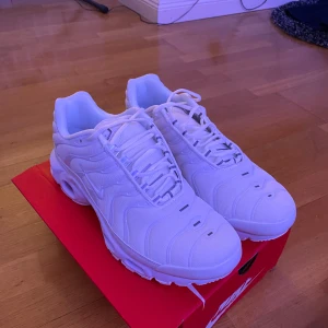 Vita tns - Snygga vita Nike sneakers med en stilren design och snörning. Perfekta för en sportig look. Skorna har en bekväm passform och är oanvänd.