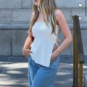 Tube top NAKD - Vit tube top med slit i storlek M. Beställde den från NAKD men har aldrig använt den då den inte passade mig, lappen sitter kvar. Bilderna är tagna från NAKD. Hör av er ifall ni har frågor eller vill ha fler bilder🫶🏼