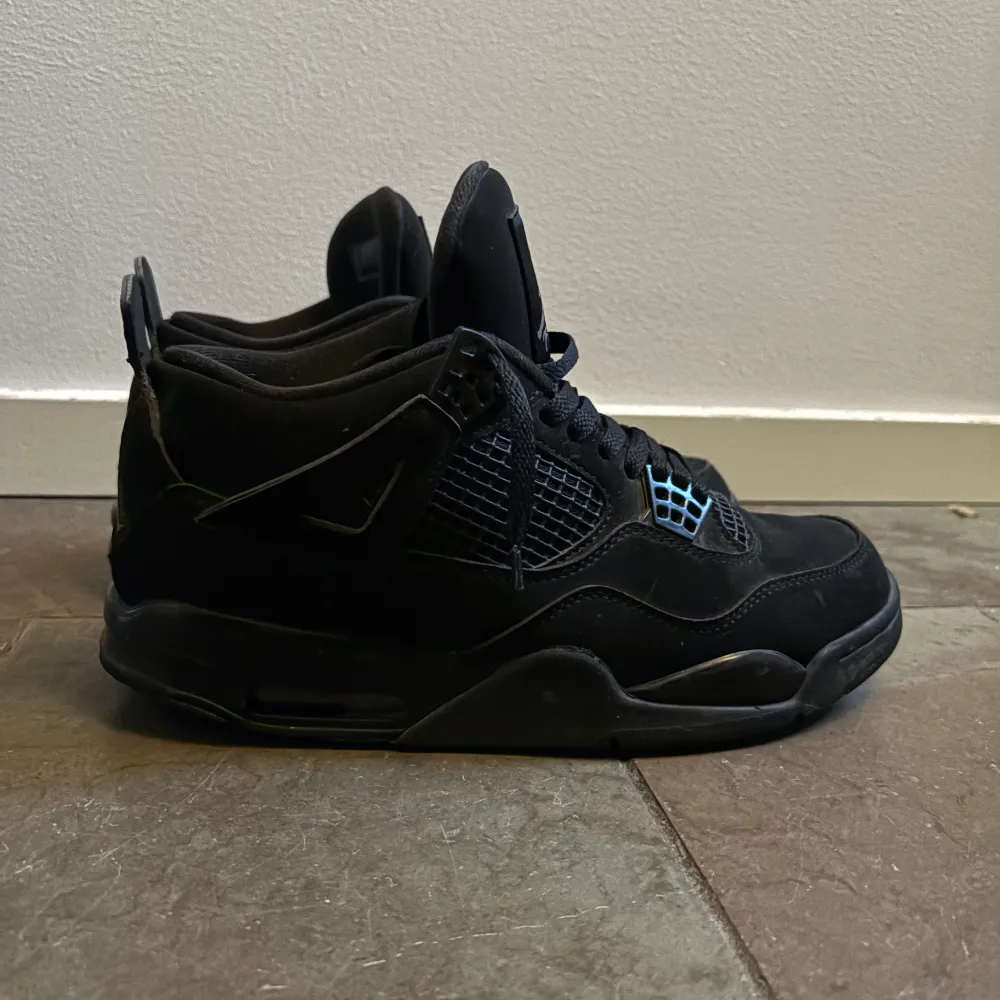 Snygga helsvarta Nike Air Jordans med klassisk design. Skorna har snörning och är tillverkade i skinn och syntetmaterial. Perfekta för dig som gillar en stilren look. Säljer mina Jordan 4 black cats för dom har blivit för små, såklart äkta!. Kengät.