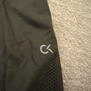 Träningsbyxor/tights från Calvin Klein - Snygga svarta leggings från Calvin Klein med diskret logga på benet. Storlek M, passar bra på mig som är S. Mörkgrön/olivfärgad 