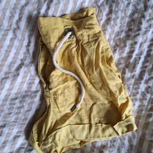Gula linneshorts - Högmidjade, gula linneshorts från Mango med knytband i midjan. Sparsamt använda.