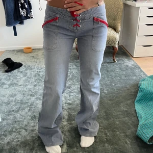 Bootcut 2000s jeans med röda detaljer! - Så snygga jeans💗lowwaist bootcut med röda detaljer. Det är i helt perfekt skick, inga slitningar alls. Innerbenslängd 78cm, midjemått 39cm(går att justera)