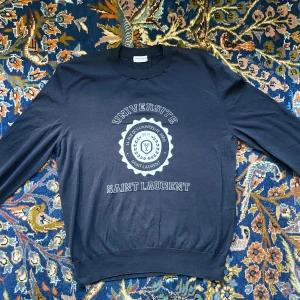 Saint Laurent Universite stickad tröja - Väldigt bra skick  Ställ gärna frågor Taggad som L, men passar M  Bröstvidd 51 cm Längd 64 cm Axelbredd 45 cm 