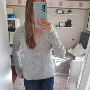 Grå kabelstickad tröja! - Mycket fin kabelstickad tröja från Tommy Hilfeger. Säljer pga att den inte kommer till användningen. Bara använd en gång, jättefint skick. Passar även S.