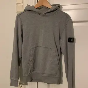 Säljer en riktigt stilren grå Stone Island hoodie. Den är i ett mycket bra skick och i princip som ny.  