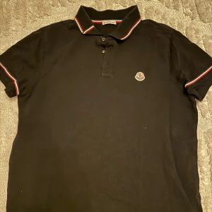 Moncler Piké  - En svart moncler piké i storlek M