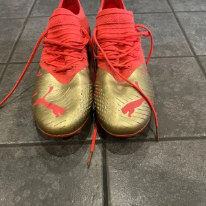Röda och guldiga fotbollsskor från Puma - Säljer ett par Puma future limited edition. De är i bra skick och endast använda en månad. 