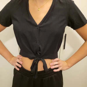 Svart topp - En svart topp med knappar från Vero Moda. Storlek S. Använd fåtal gånger.