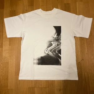 Maison margiela t-shirt - Säljer den här vita Maison margiela t-shirten med tryck. Den är i storlek S men passar M.passformen är ganska baggy. Den passar bäst på 180-185