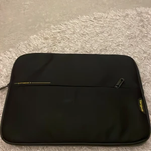 Svart datorväska från Targus - Säljer en stilren svart datorväska från Targus, perfekt för att skydda din dator / annat. Väskan har en praktisk dragkedja och är tillverkad i slitstarkt material. Den är i bra skick.