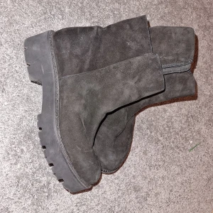 Svarta mockaboots med dragkedja - Snygga svarta boots i mocka med dragkedja på sidan. Perfekta för höst och vinter med en robust sula för extra grepp. Stilrena och enkla att matcha med olika outfits.