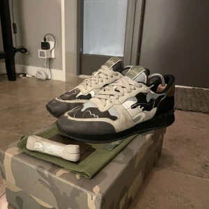 Camouflage sneakers från Valentino - Snygga sneakers från Valentino i ett coolt camouflage-mönster. Skorna har snörning och en kombination av olika material som ger en unik look. Perfekta för dig som vill sticka ut!