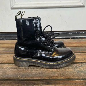 Svarta lackade Dr Martens - Snygga svarta lackade kängor från Dr. Martens! Precis inköpta på tradera, säljer vidare då de var för små för mig. Kängorna är använda men i mkt bra skick😙