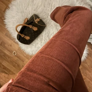 RödBruna manchesterbyxor - Snygga rödbruna manchesterbyxor med bootcut-stil. Perfekta för en trendig look med låg midja. Byxorna har en knapp och dragkedja framtill hör av er för fler bilder eller frågor 🤍