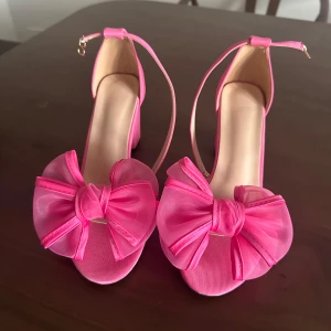 Rosa klackskor med rosett - Rosa klackeskor aldrig använda storlek 38