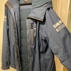 Blå jacka från Sail Racing - Sällsynt snygg blå jacka från Sail Racing med GORE-TEX-material. Perfekt för vintern och hösten. Bra material på jackan, skyddar från regn och snö.