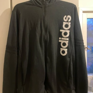 Adidas Kofta  - Adidas kofta storlek L herr, använd men bra skick.  Något nopprig, och på ena ärmen (bild 2) så har ena strecket släppt lite men går att sy till för den som är kunnig. 