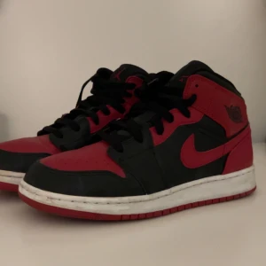 Nike Air Jordans i svart och rött - Snygga Nike Air Jordans i svart och rött med klassisk design. Skorna har en hög siluett och snörning framtill. Dom har inga skador eller liknade och dom är i top skick och säljer för jag köpte dom när jag var yngre men kom inte till så mkt användning då jag växte ur dom väldigt snabbt  