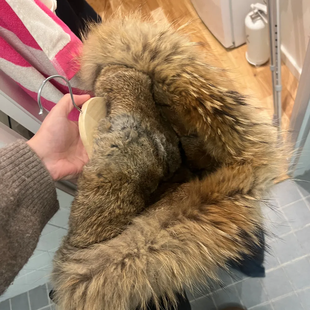 Snygg svart parkajacka från Blonde. Nr8 med pälsfodrad huva och camouflagemönstrat foder. Jackan har knappar och dragkedja framtill för extra skydd mot kyla. Perfekt för kalla dagar!. Takit.