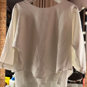 Vit blus från VILA - Säljer en stilren vit blus från VILA med trekvartsärmar. Blusen har en lös passform och är tillverkad i ett lätt och luftigt material, perfekt för vår och sommar. Passar bra till både jeans och kjol. Ser lite skrynklig ut på bild men det är inget permanent. Skriv vid frågor💞