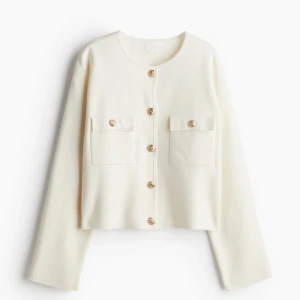 Vit kavaj med knappar - Elegant vit kavaj med rund hals och dekorativa knappar framtill. Två fickor på bröstet ger en stilren look. Perfekt för en chic och sofistikerad stil.